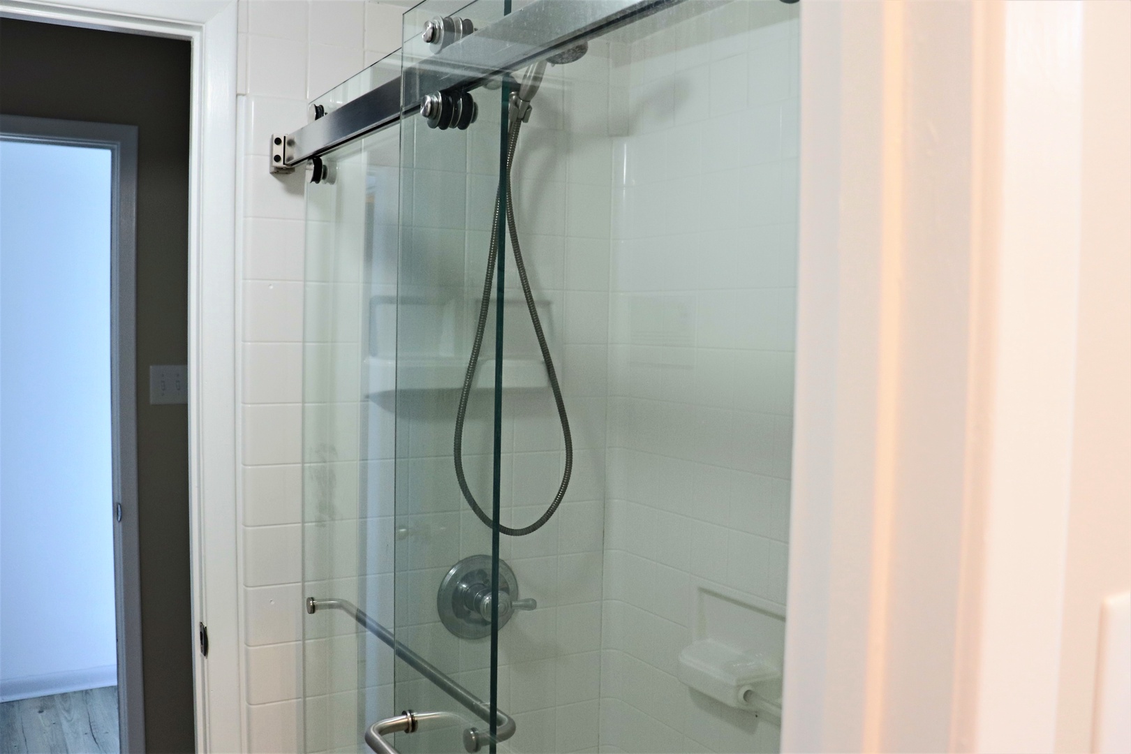 Step into your sleek glass-enclosed shower with modern fixtures and rainfall showerhead for the ultimate relaxing experience.