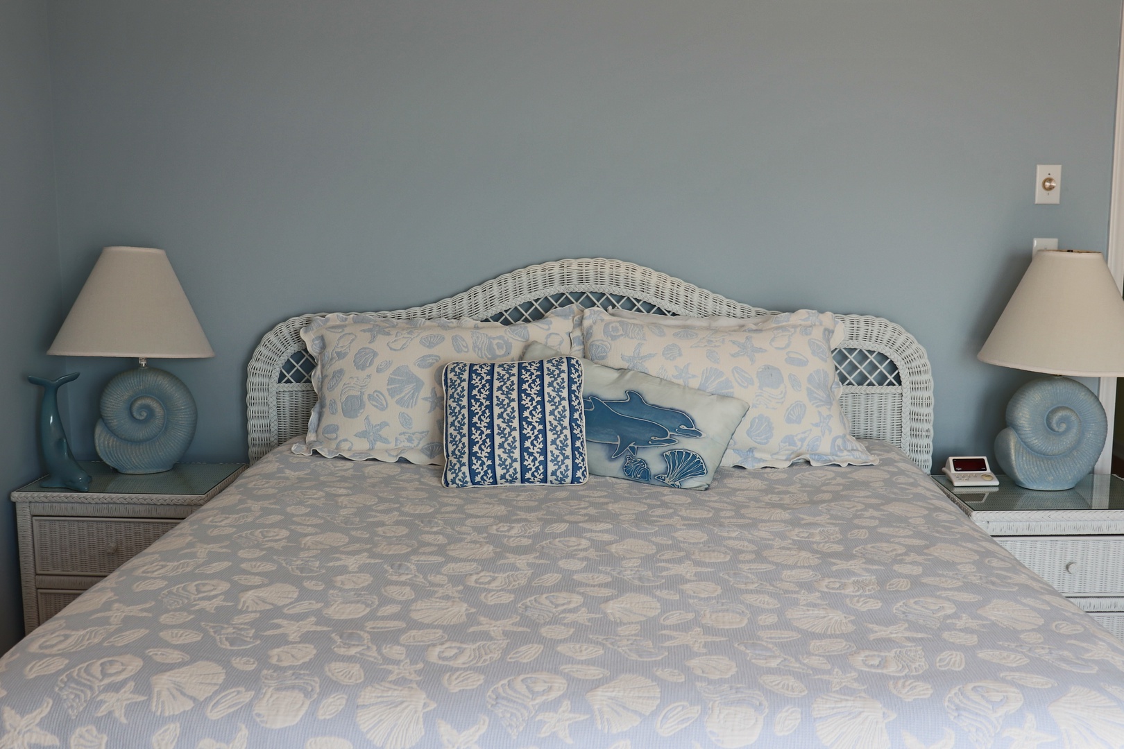 Drift into peaceful sleep in this coastal-themed bedroom where soft blue hues and shell patterns create your perfect seaside retreat.