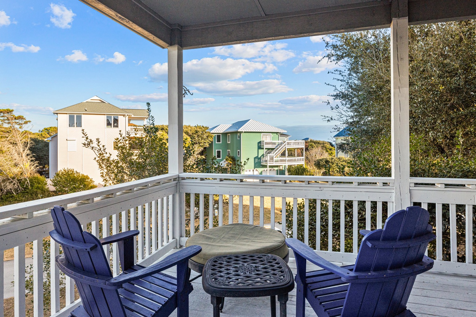 Unwind on your private covered balcony with comfortable seating and peaceful neighborhood views.