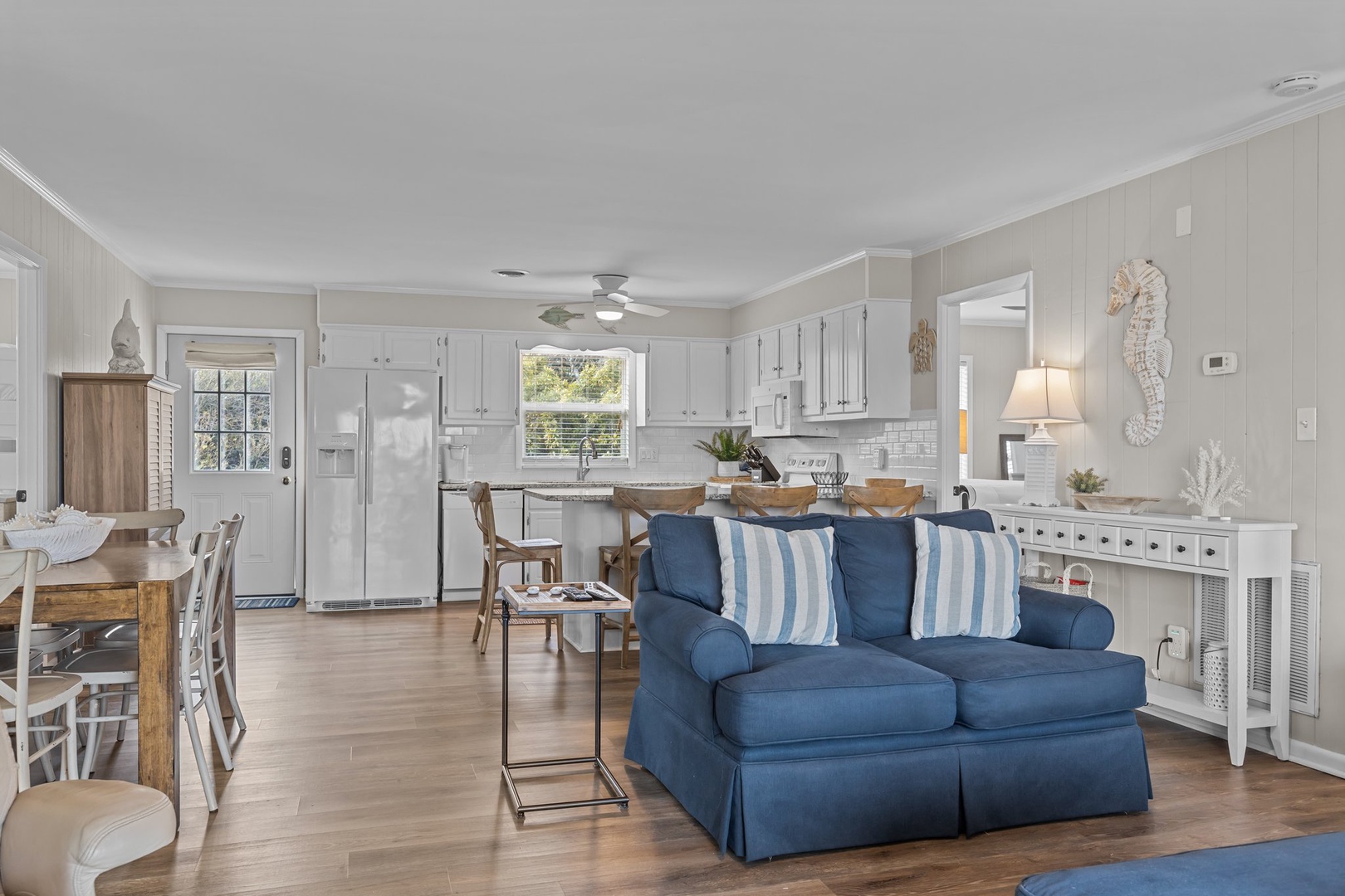 Unwind in your coastal-inspired open living space, where soft blue furnishings and white shiplap create the perfect seaside retreat atmosphere.