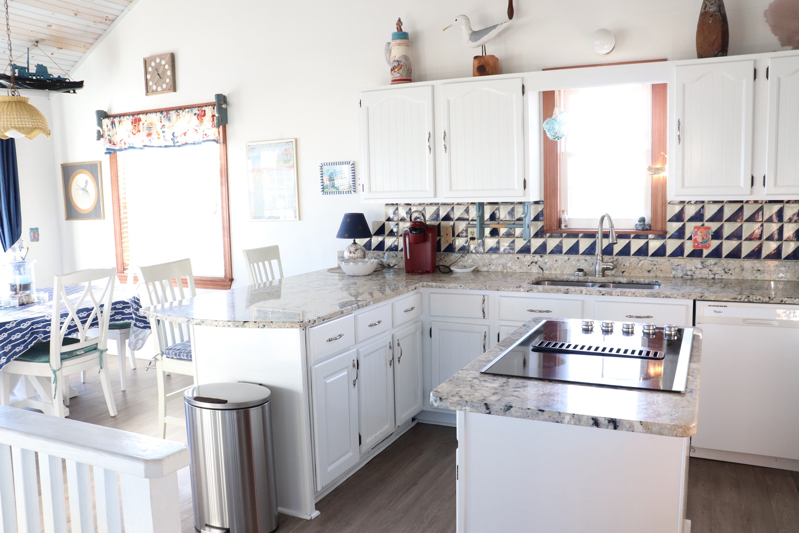 Your bright kitchen welcomes you with white cabinets, granite counters, and charming nautical tile backsplash—perfect for cooking memorable meals.