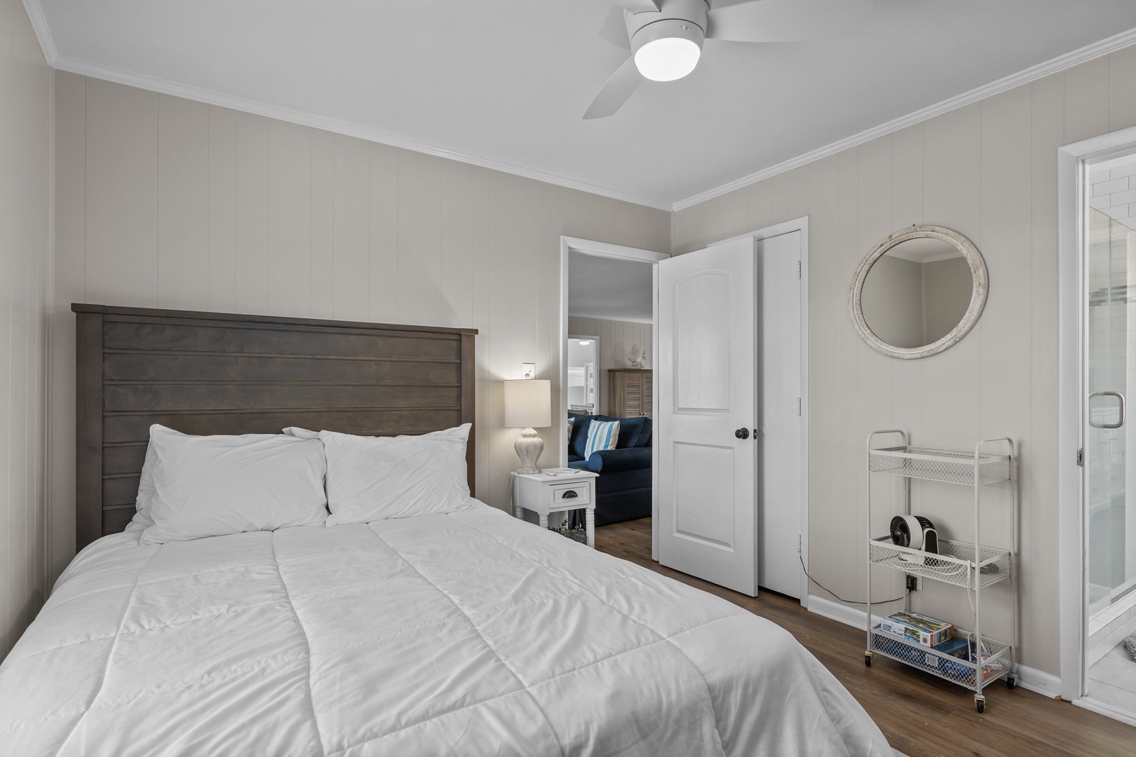 Drift off in your serene bedroom with crisp white linens, soothing coastal tones, and gentle ceiling fan for perfect comfort.