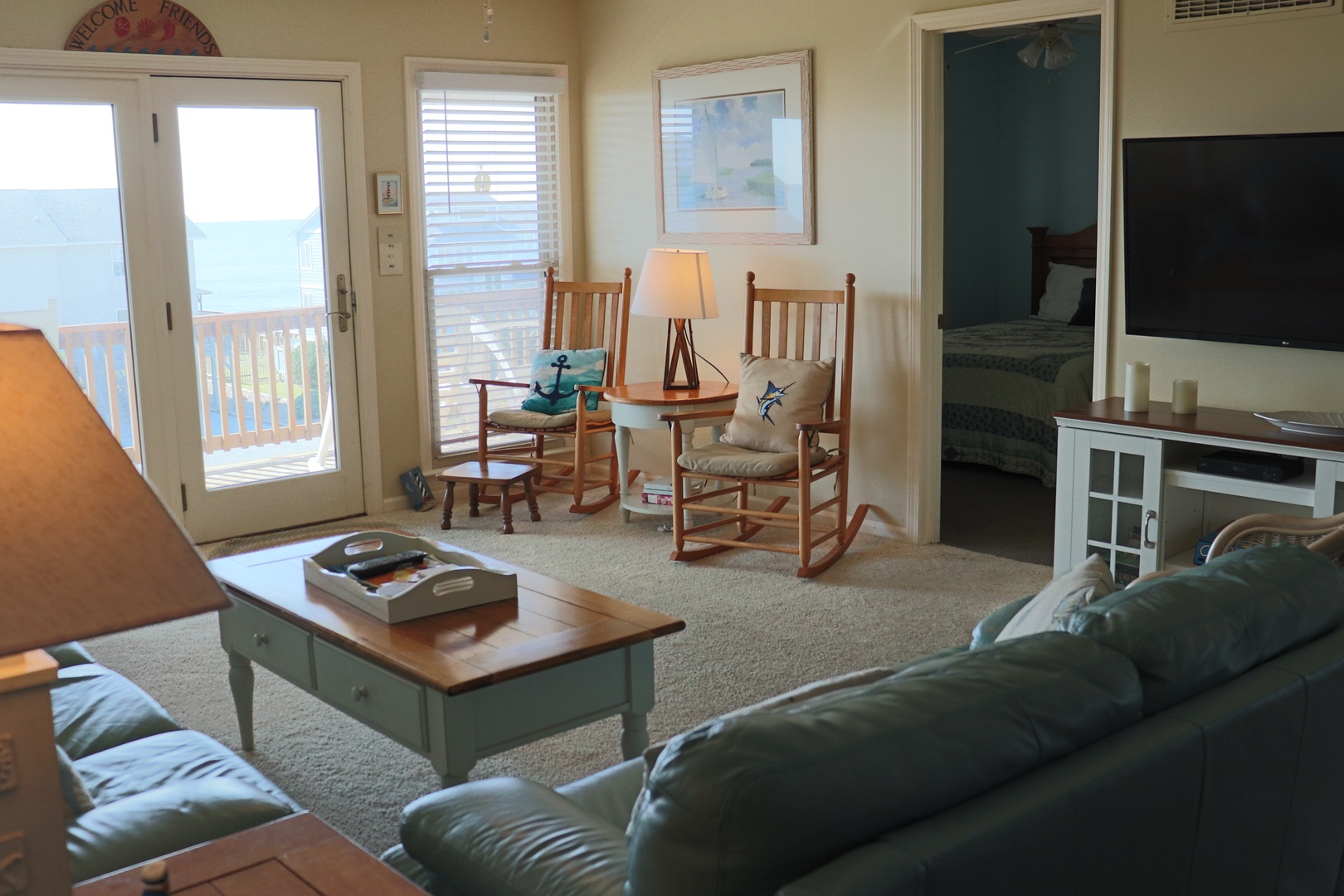 Settle into your cozy living room where rocking chairs await by the balcony doors, perfect for morning coffee or evening relaxation.