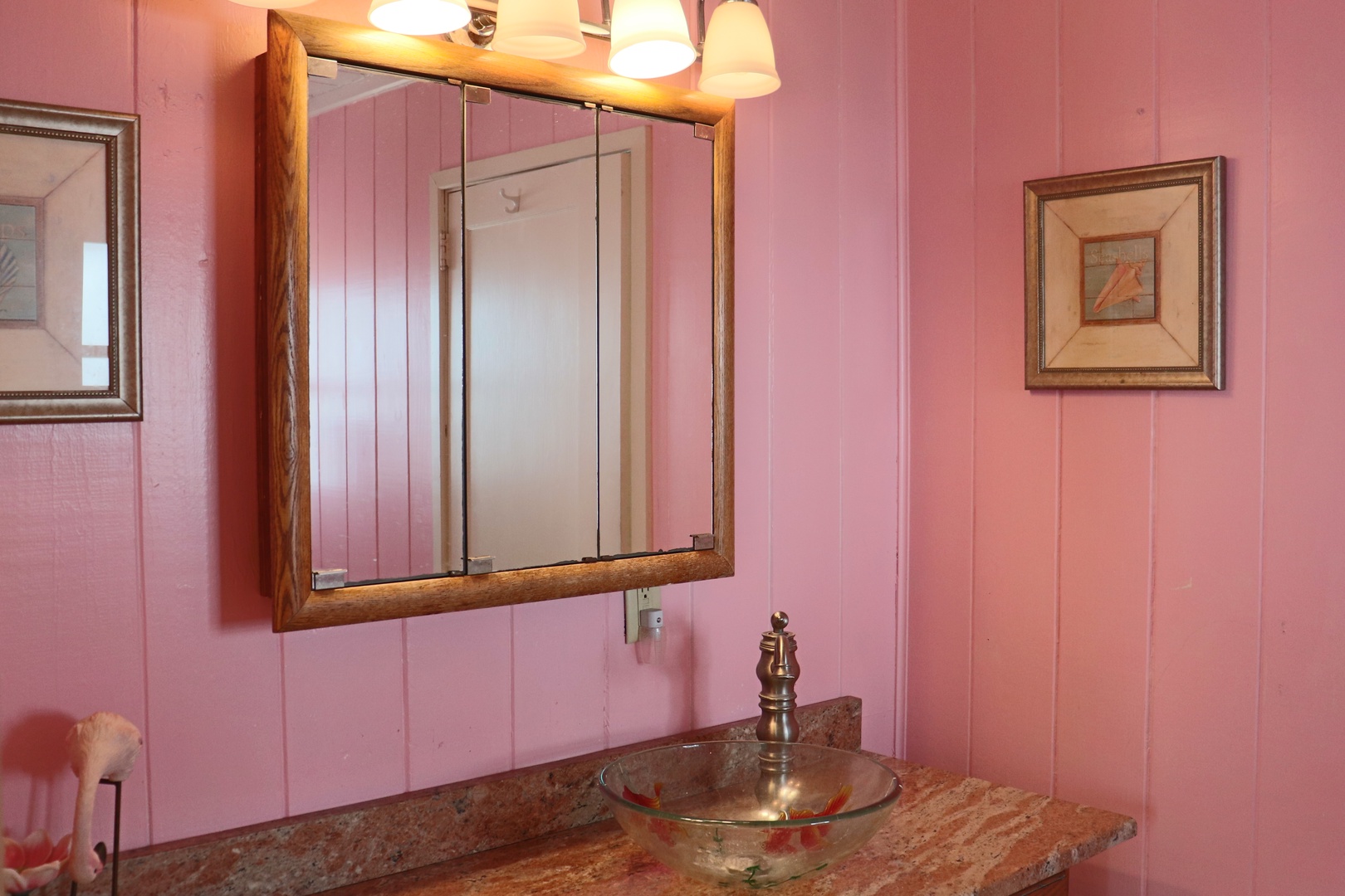 Step into your charming pink bathroom featuring rustic wood accents and vintage brass fixtures that create a cozy, cottage-like atmosphere.