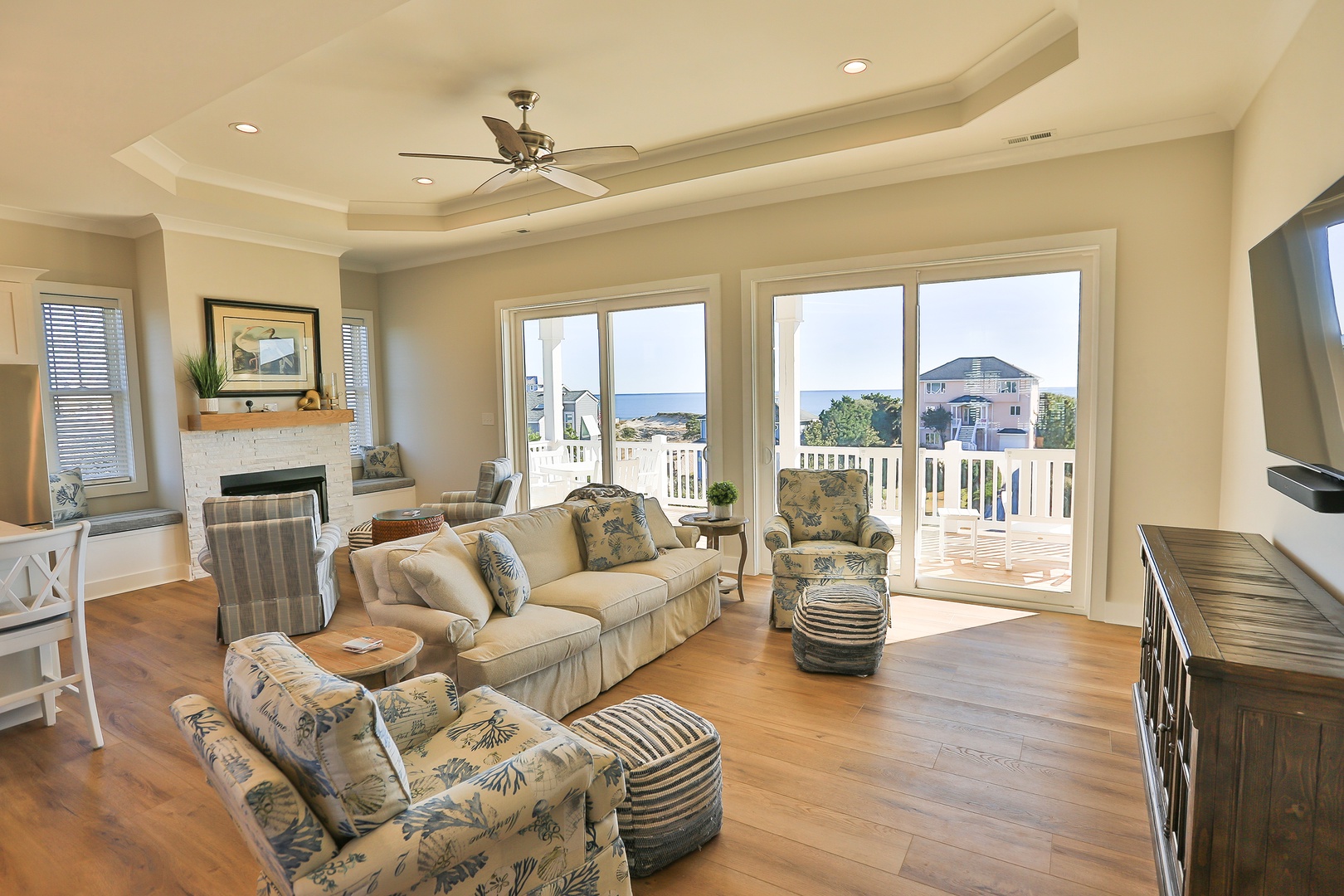 Relax in your elegant living room with soaring ceilings, cozy fireplace, and stunning ocean glimpses through expansive windows.