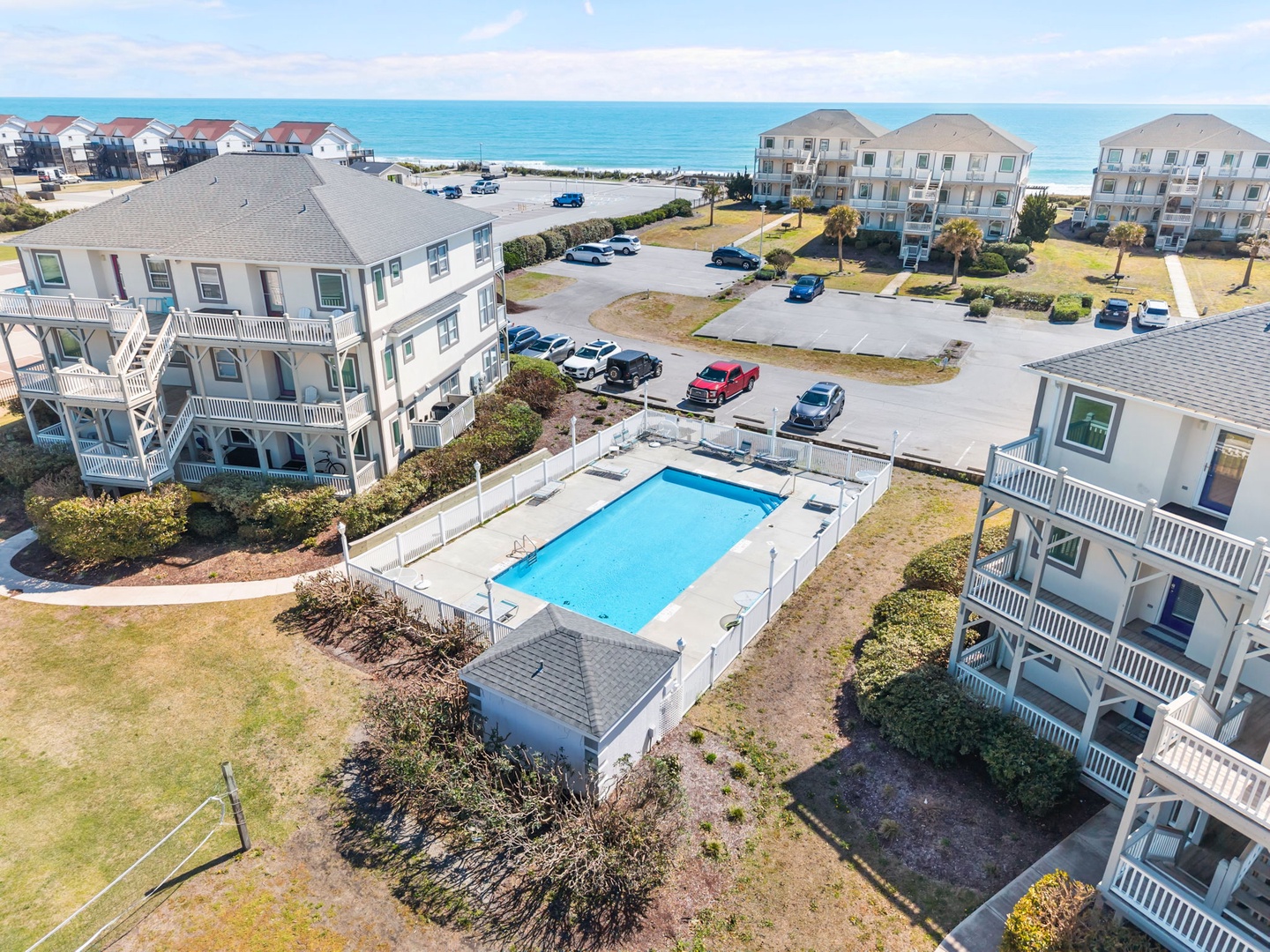 Beachfront vacation rental complex with swimming pool, parking, and direct beach access just steps from the ocean.