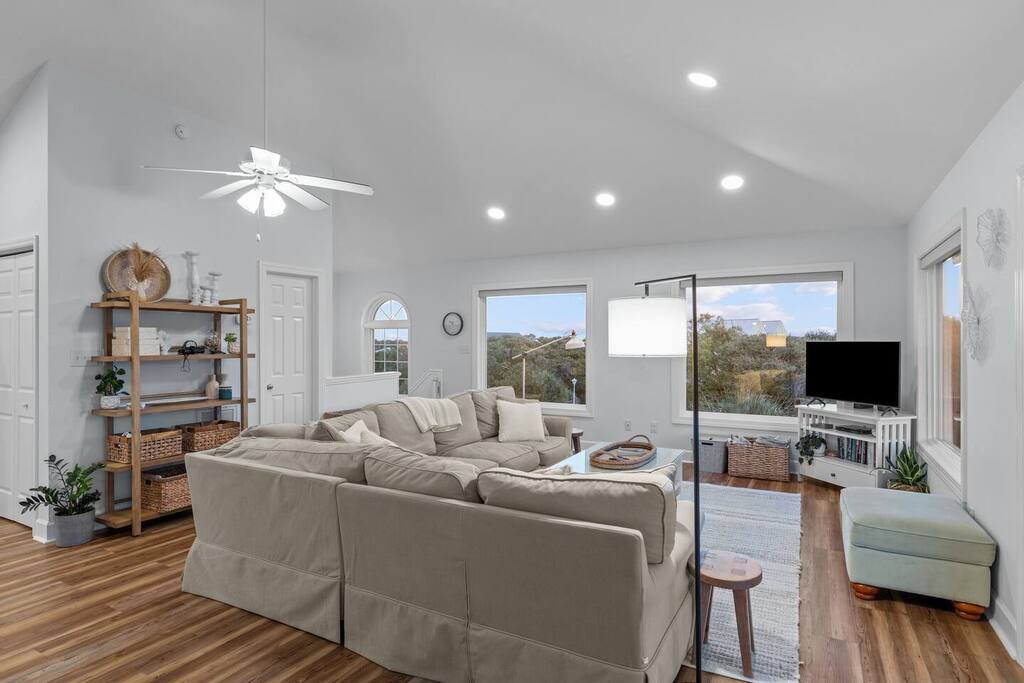 Sink into plush sectional seating while natural light streams through large windows, creating your perfect retreat for relaxation and entertainment.