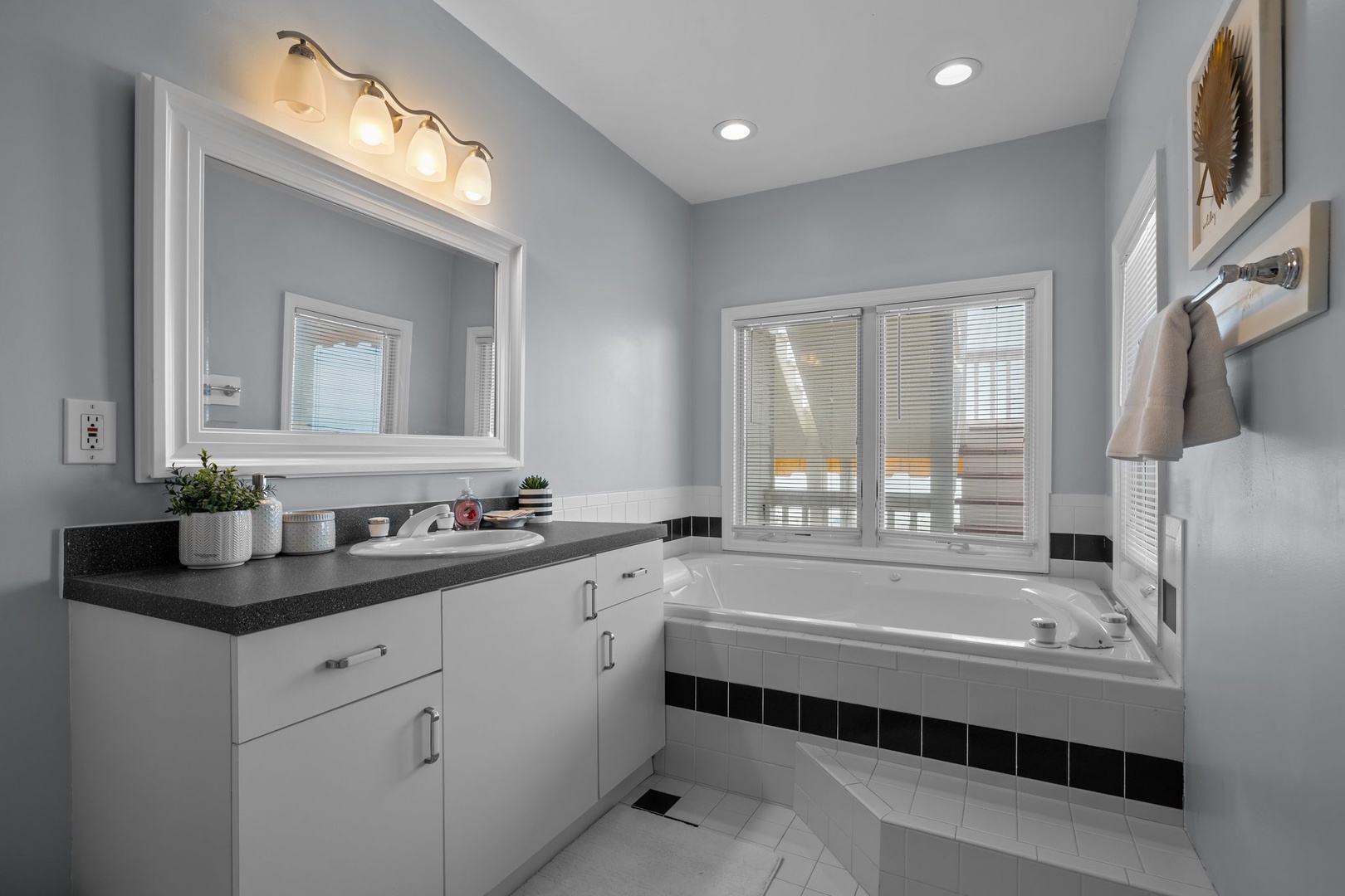Soak away your stress in this elegant bathroom sanctuary, featuring a deep soaking tub with natural light and stylish touches.