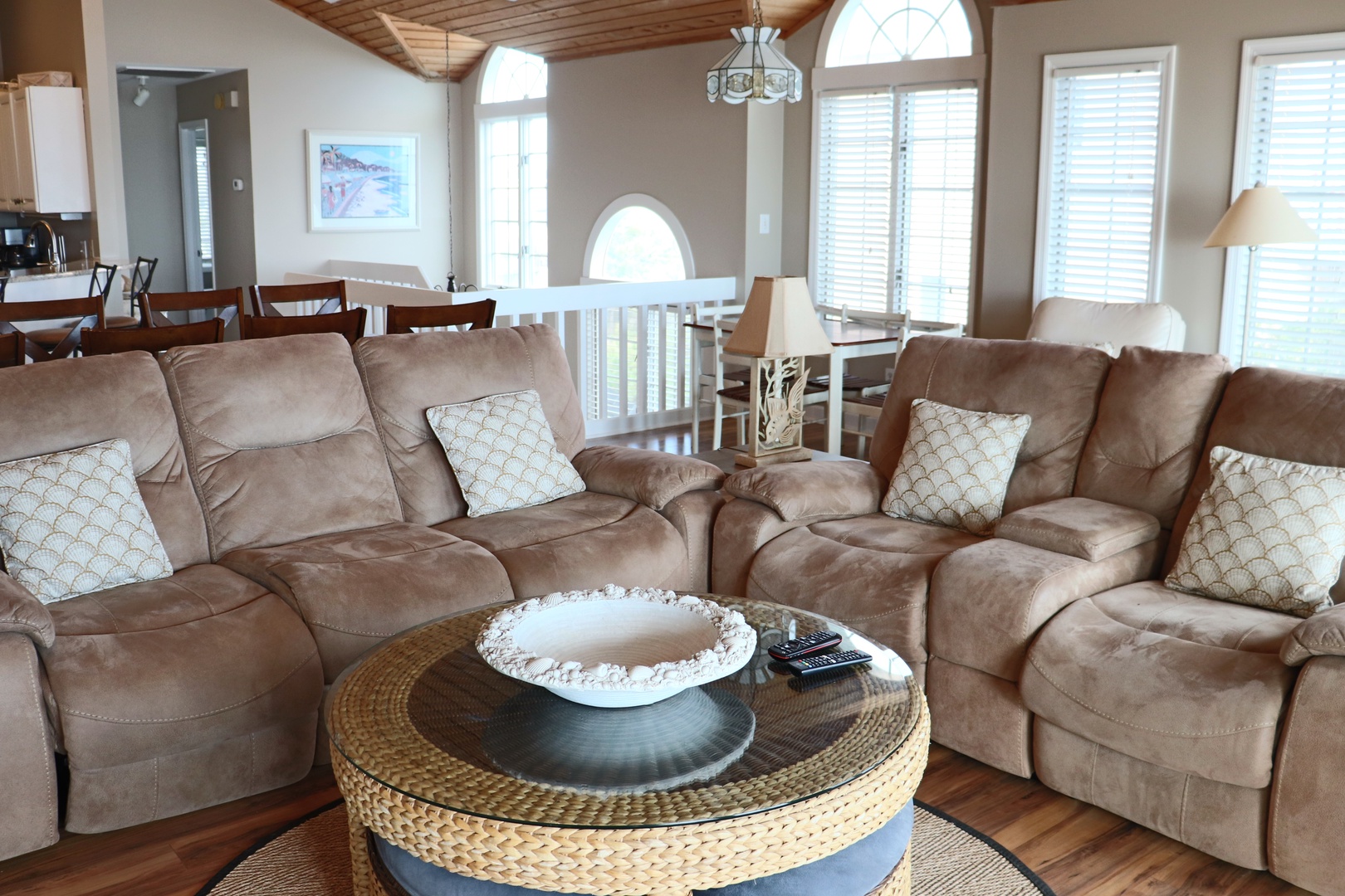 Sink into plush reclining sofas in this open living space where wooden ceilings create warmth above your comfortable gathering spot.