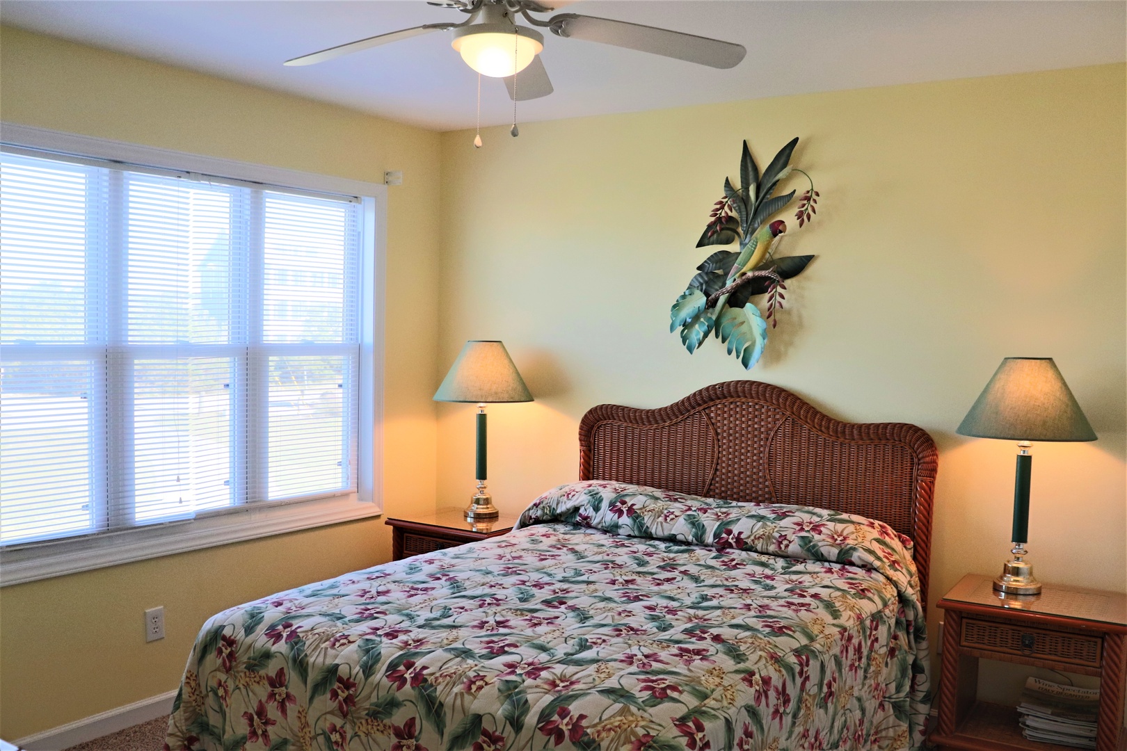 Drift off in your tropical-themed bedroom with floral bedding, wicker headboard, and gentle ceiling fan creating the perfect island breeze.
