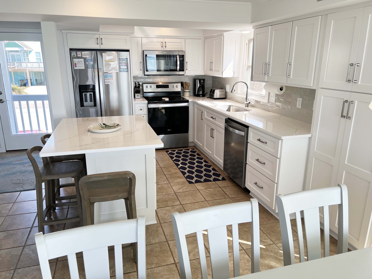 Your bright, modern kitchen features white cabinets, stainless steel appliances, and a convenient island for meal prep and casual dining.