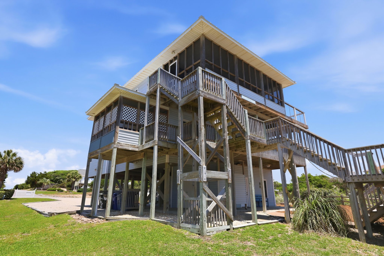 Elevated beachfront architecture on stilts with spacious wraparound decks, ideal for coastal living and enjoying expansive outdoor views near the shoreline.