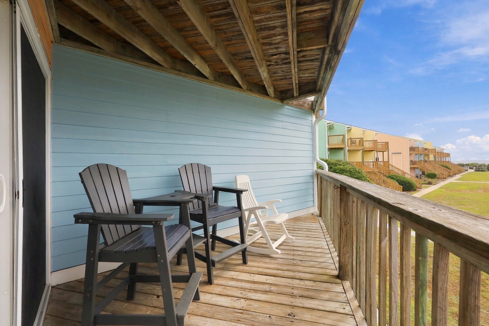 Settle into your morning coffee on this cozy deck, where Adirondack chairs invite you to unwind and soak in the peaceful coastal breeze.