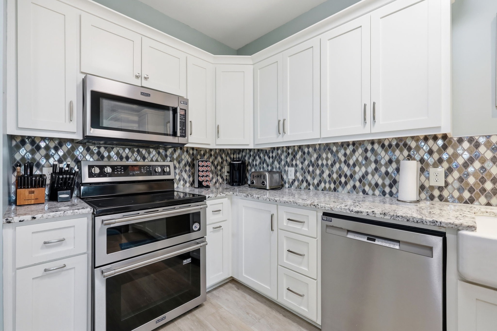 Your fully equipped kitchen features granite countertops, modern stainless steel appliances, and eye-catching tile backsplash—perfect for preparing delicious home-cooked meals during your stay.