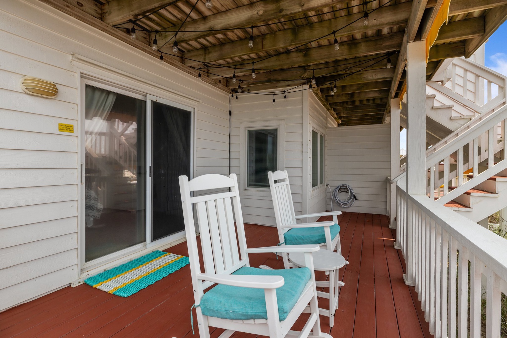 Unwind on your private covered patio with cozy rocking chairs and turquoise cushions—the perfect spot for morning coffee or evening relaxation.