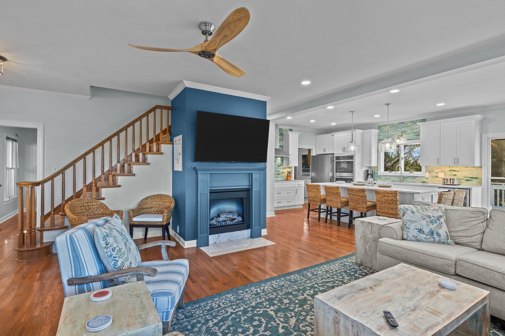 Relax in your open-concept living space with cozy fireplace, modern kitchen, and coastal-inspired decor perfect for memorable gatherings.