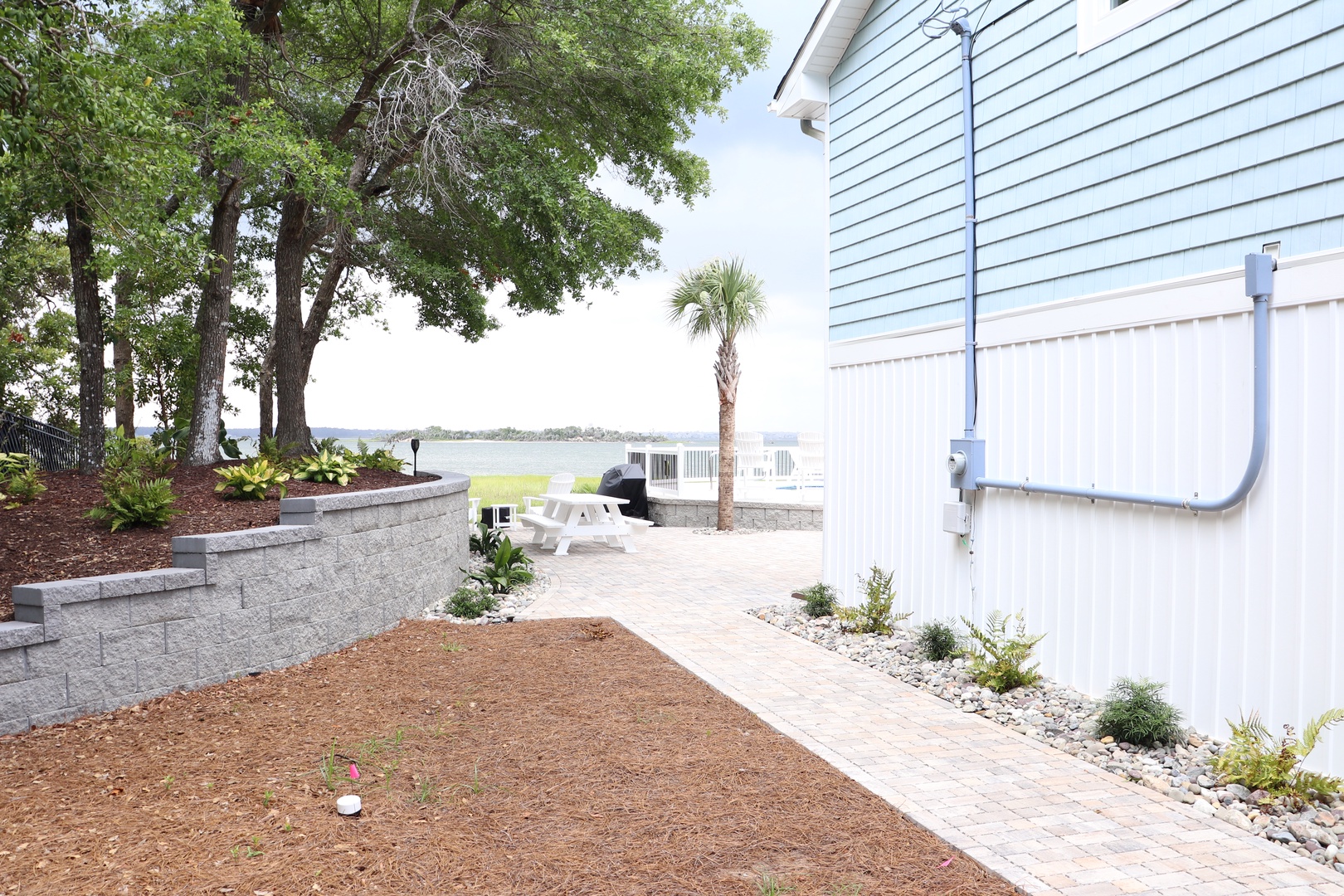 Waterfront property featuring landscaped grounds with mature trees and direct lake access for guests.