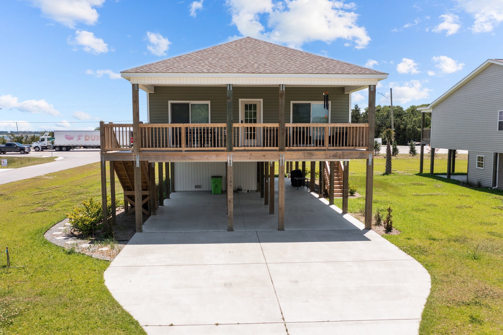 Elevated coastal home with covered parking and spacious deck overlooking the neighborhood.