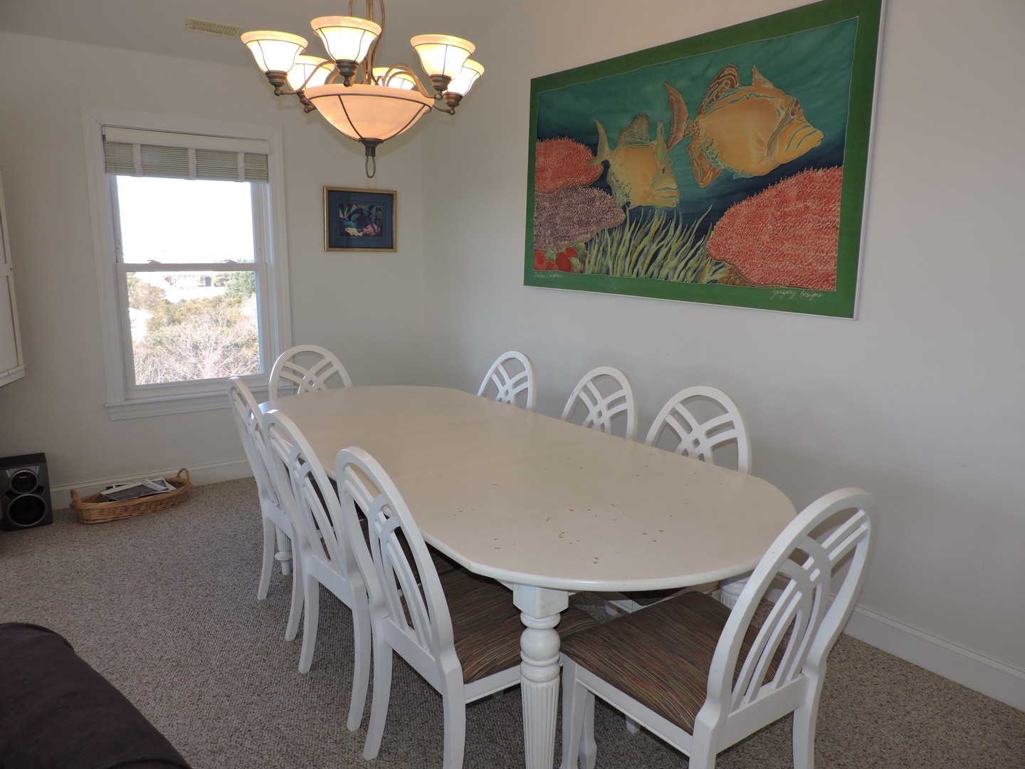 Gather around your spacious dining table where warm lighting and coastal artwork create the perfect setting for memorable meals together.