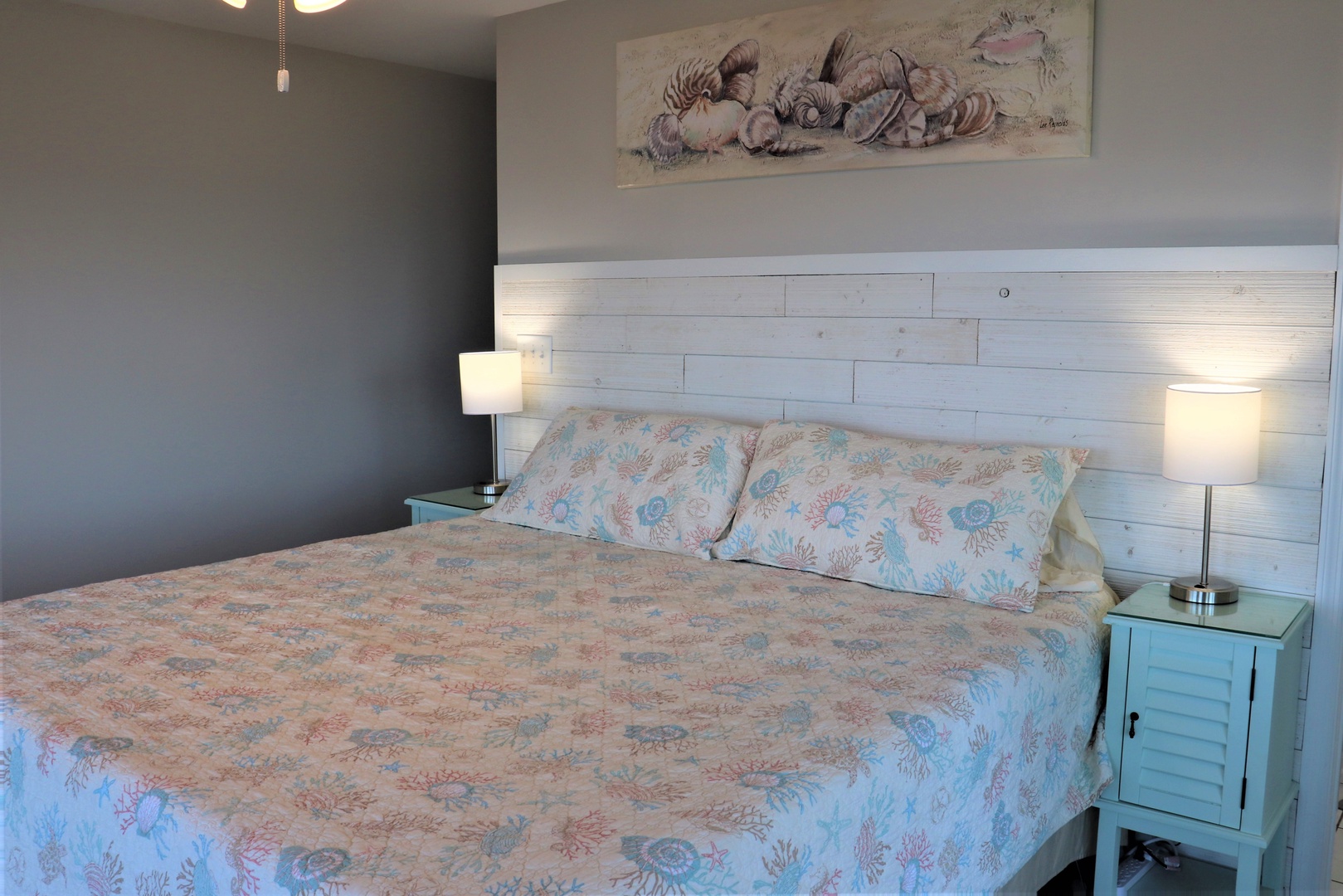 Drift off to peaceful sleep in your cozy bedroom with soft bedside lighting and coastal-inspired decor.