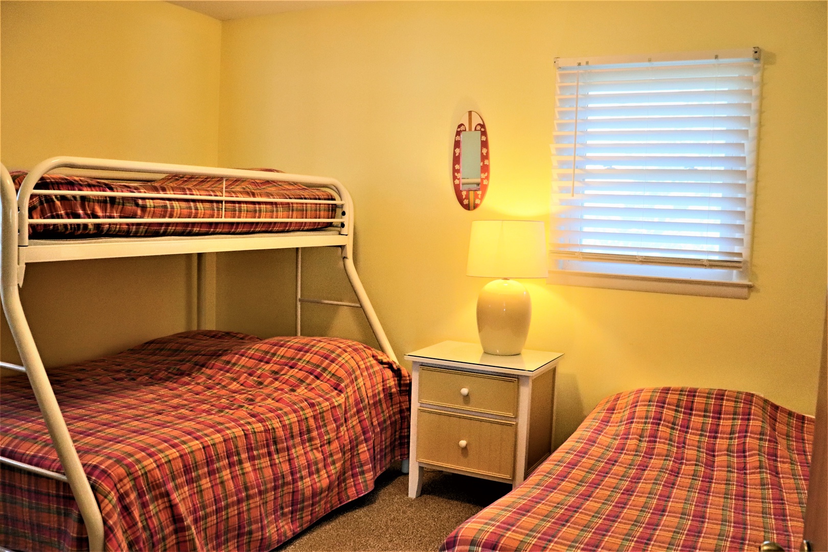 Your kids will love this cozy bedroom with cheerful plaid bedding, bunk beds for adventure, and warm lighting for bedtime stories.