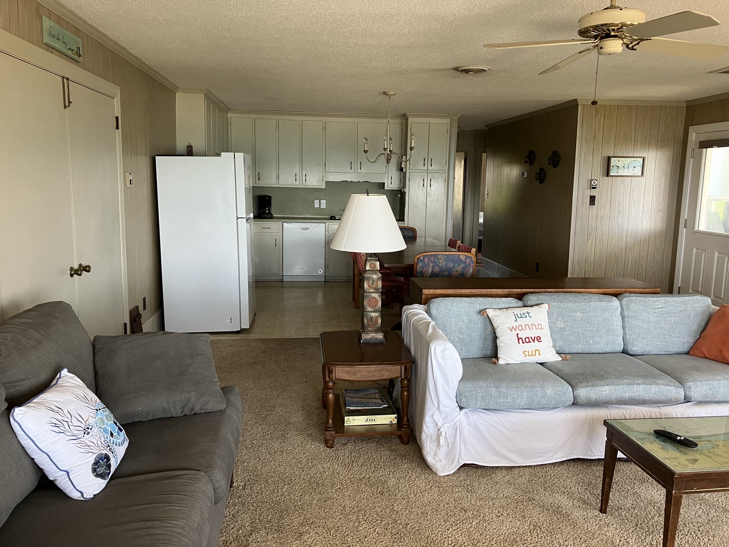 Relax in your spacious living room with comfy seating and fully equipped kitchen, perfect for preparing meals and unwinding after beach days.