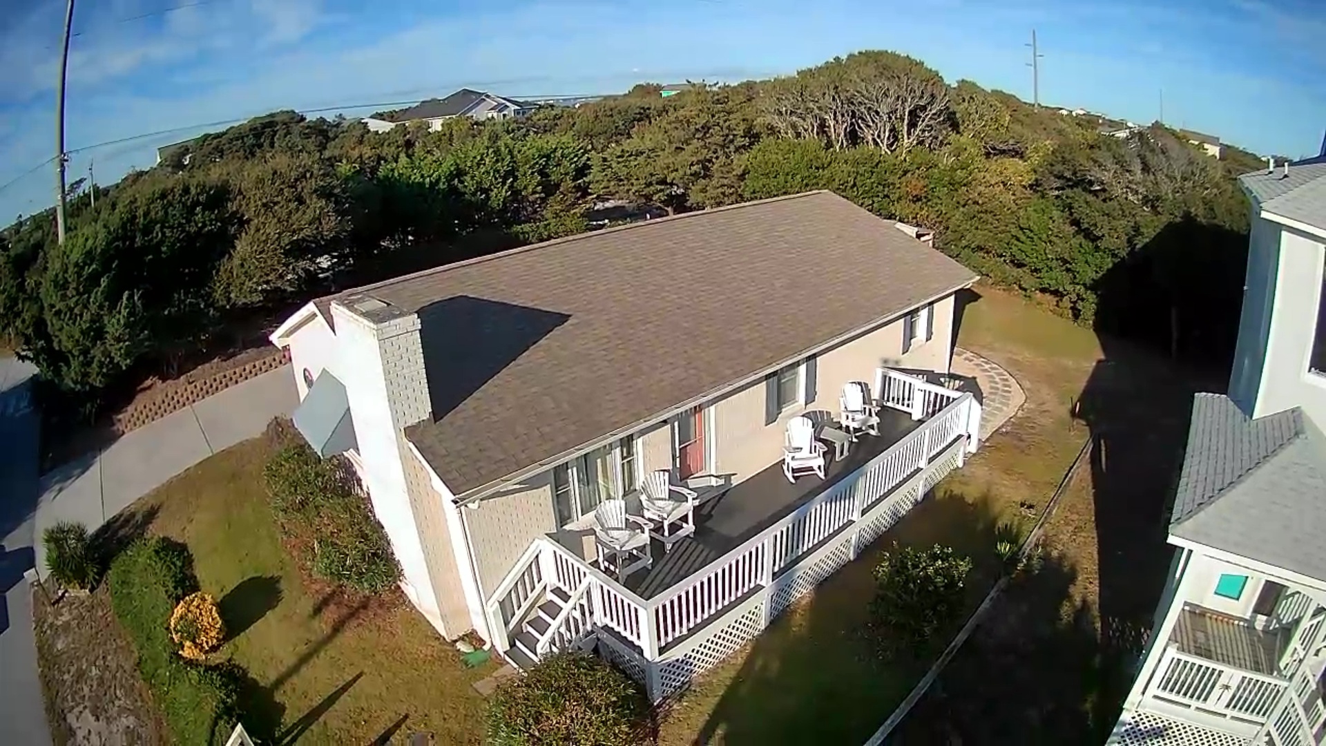 Beachfront property nestled among coastal dunes and lush vegetation, featuring spacious deck and convenient neighborhood location.