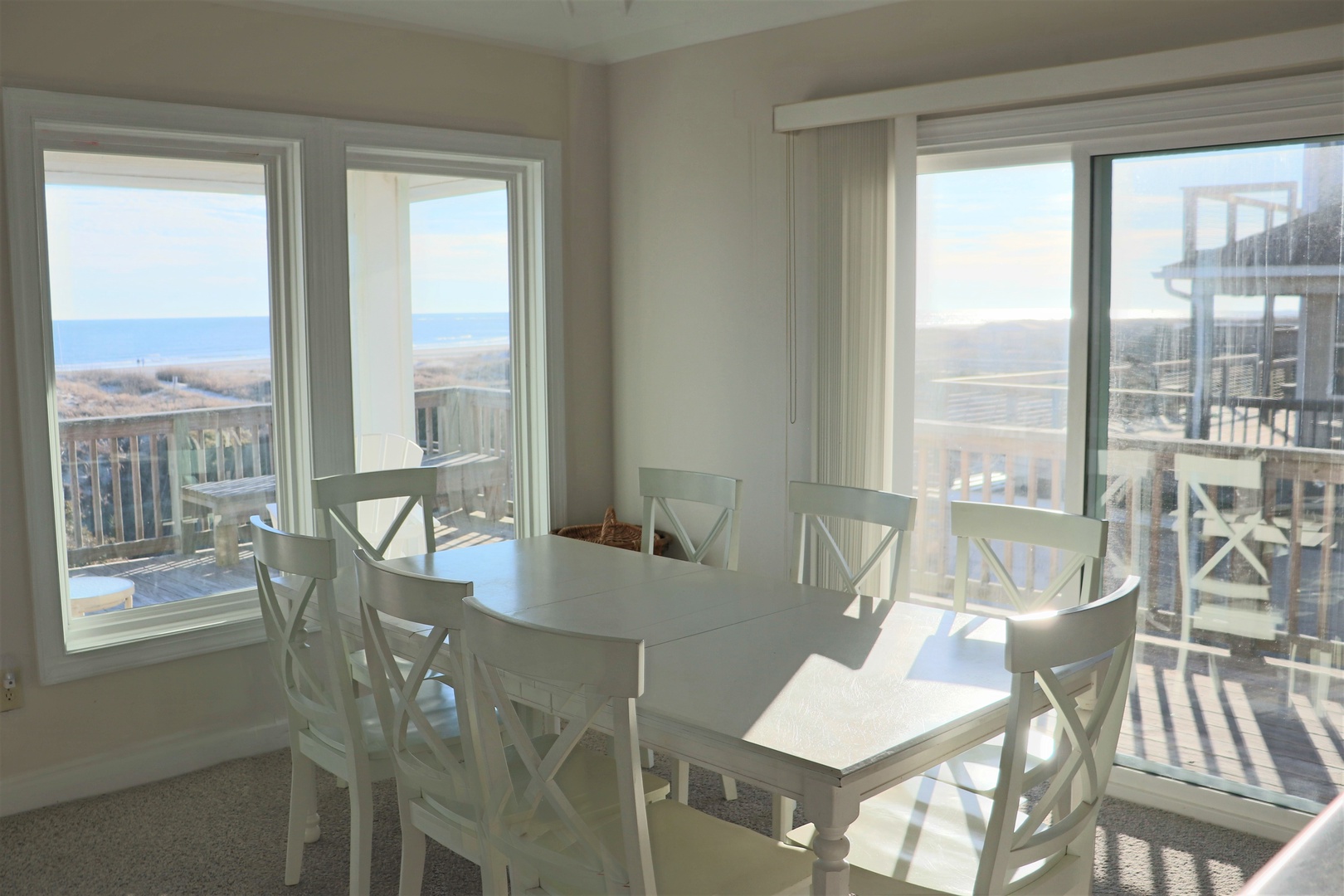 Enjoy morning coffee at your bright dining table while gazing at stunning ocean views through floor-to-ceiling windows.