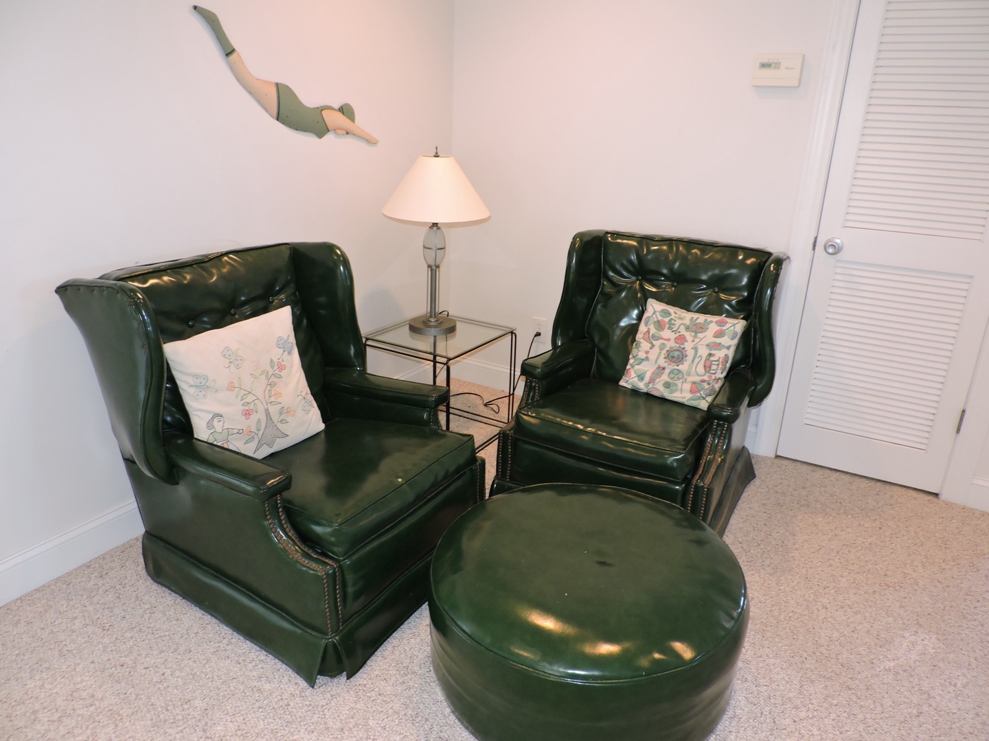 Sink into rich leather chairs with decorative pillows for your perfect reading nook, complete with warm lighting and a matching ottoman for ultimate relaxation.