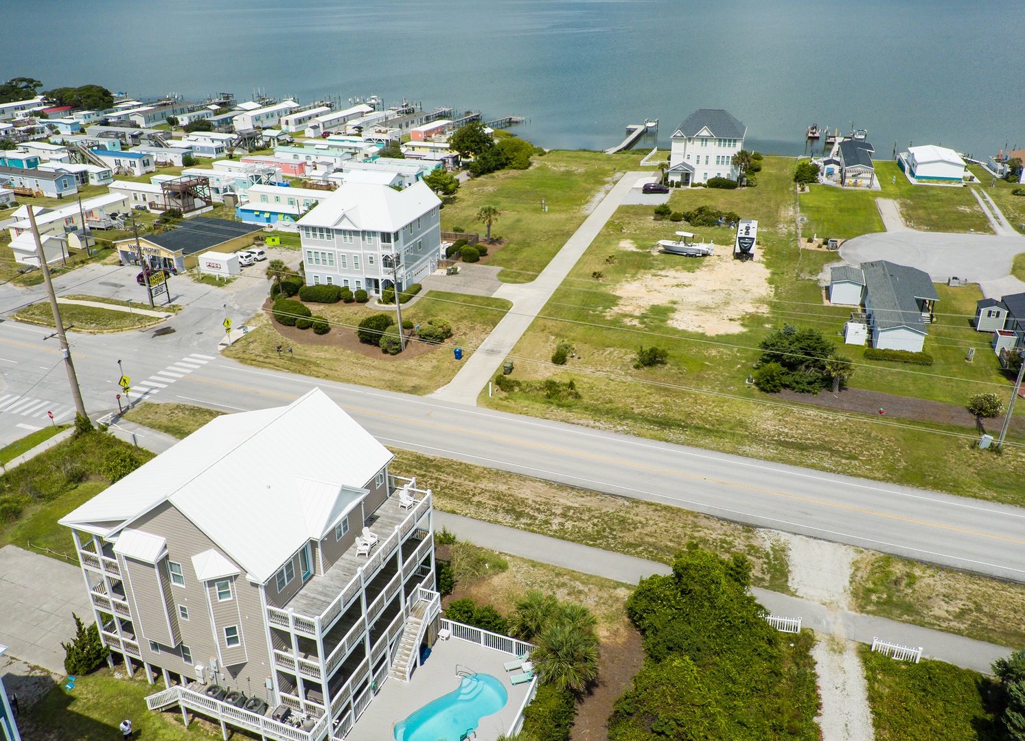 Aerial view of a coastal community featuring vacation homes, waterfront access, and residential neighborhoods near the water.