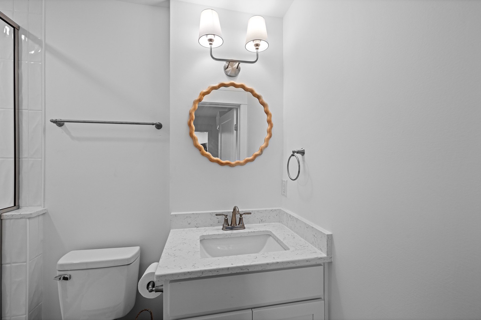 Your bright, clean bathroom features elegant scalloped mirror details and polished marble counters for your comfort.