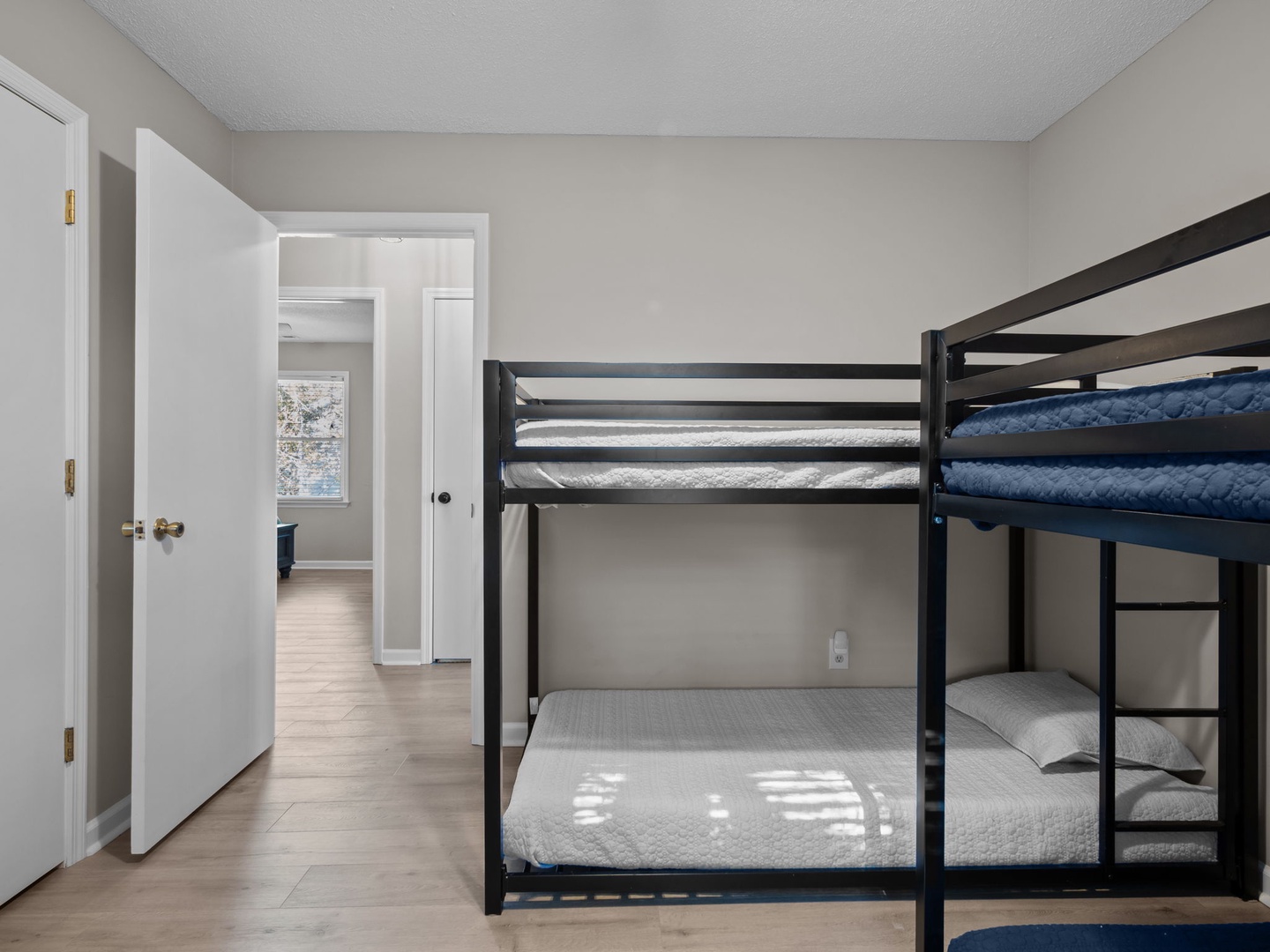 Rest comfortably in your modern bunk bed setup with fresh linens and convenient bedside storage in this bright, welcoming room.