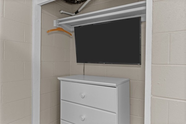 Your spacious walk-in closet combines smart storage with entertainment—a wall-mounted TV and dresser keep you organized and entertained while getting ready.