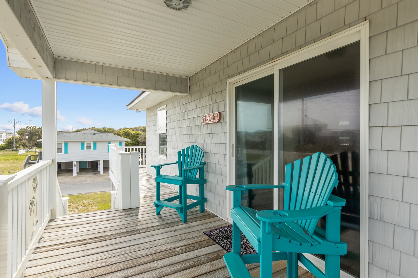 Step onto your private balcony and settle into vibrant turquoise chairs, where you can sip your morning coffee while gazing at the peaceful coastal neighborhood.