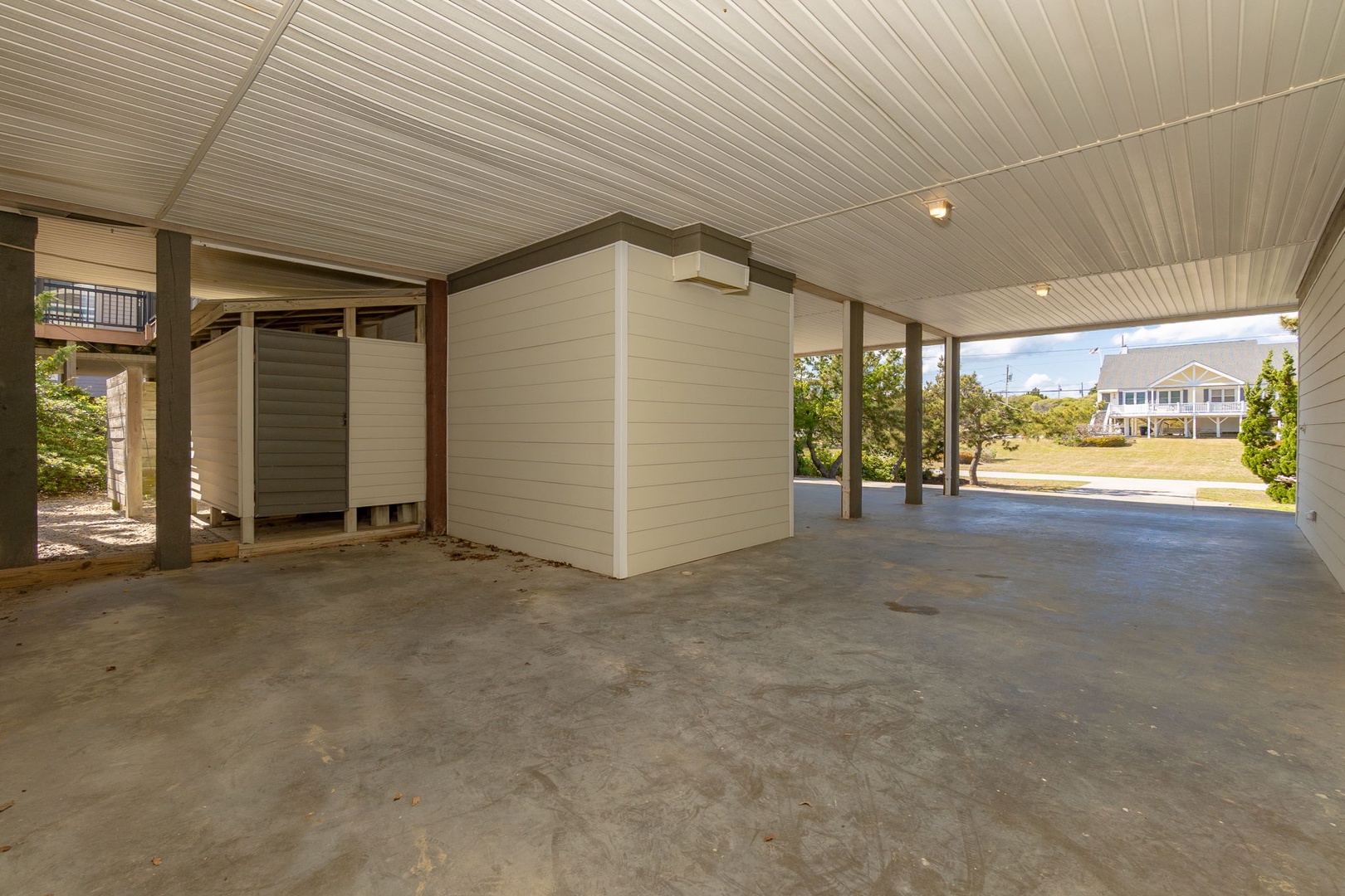 Spacious covered parking area with convenient storage space beneath the elevated property.
