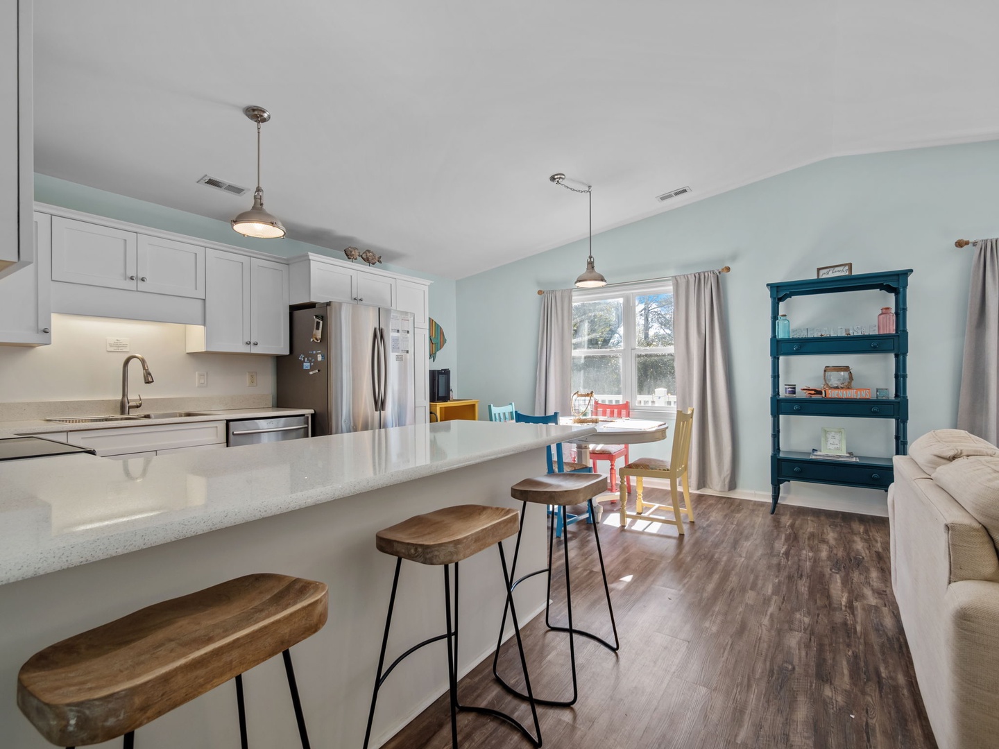 Your open kitchen flows into a bright dining space where you'll enjoy meals together, complete with modern appliances and cheerful breakfast bar seating.