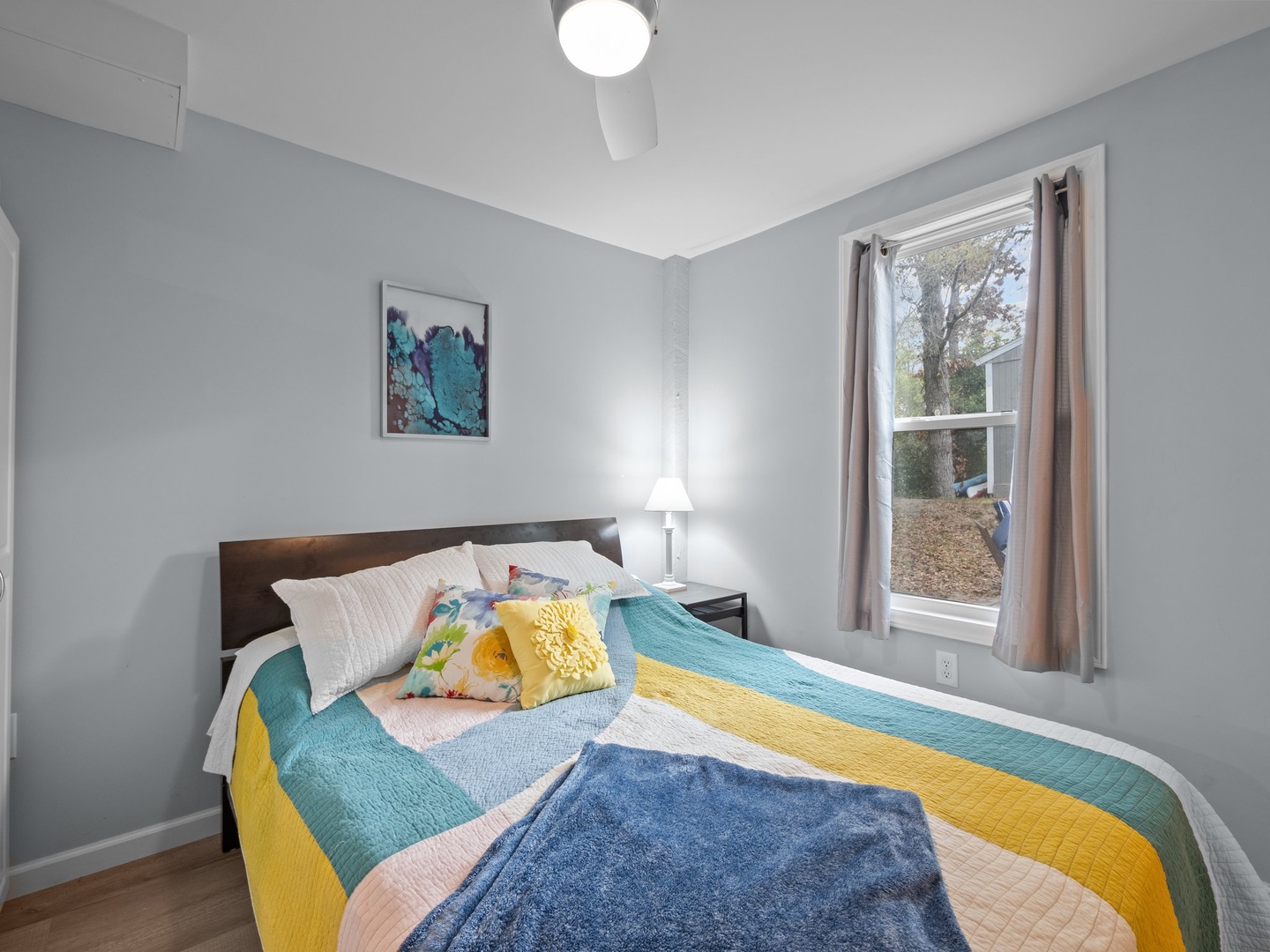 Drift into peaceful dreams in this cheerfully decorated bedroom, where vibrant quilted bedding and gentle natural light create your perfect restful retreat.