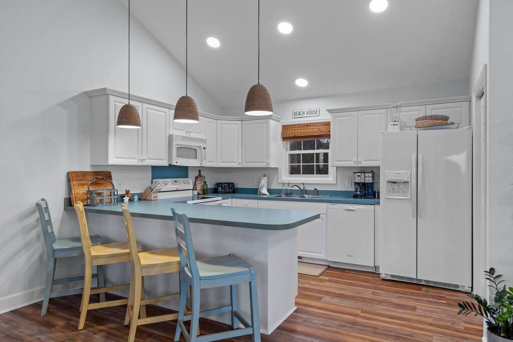 Your bright, coastal-inspired kitchen features a breakfast bar where you can sip morning coffee under charming pendant lights.