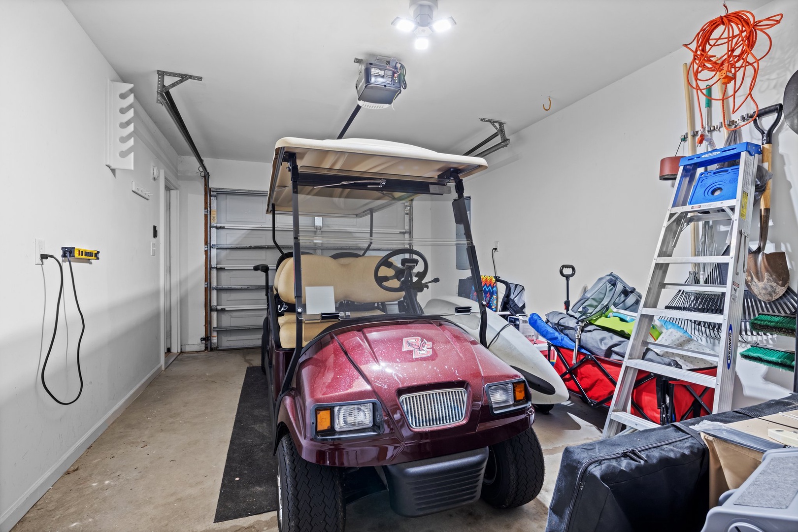 Secure garage storage space with golf cart and equipment for your convenience.