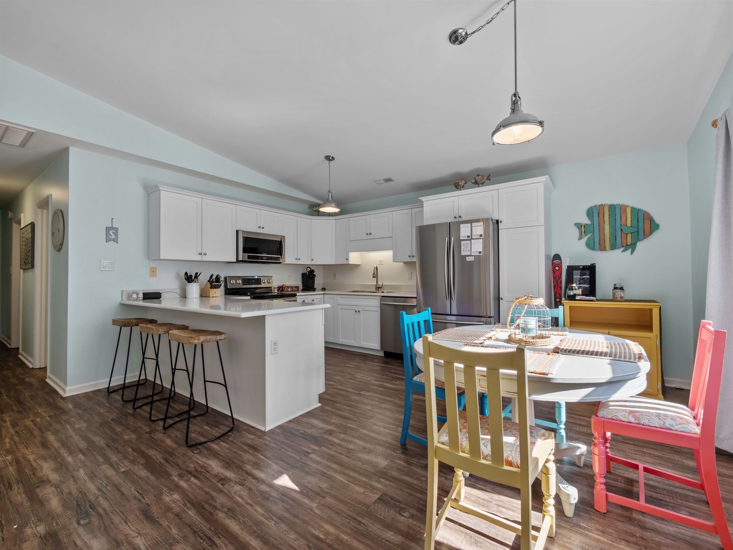 Bright, family-friendly kitchen with colorful dining chairs and breakfast bar where you can whip up meals together.