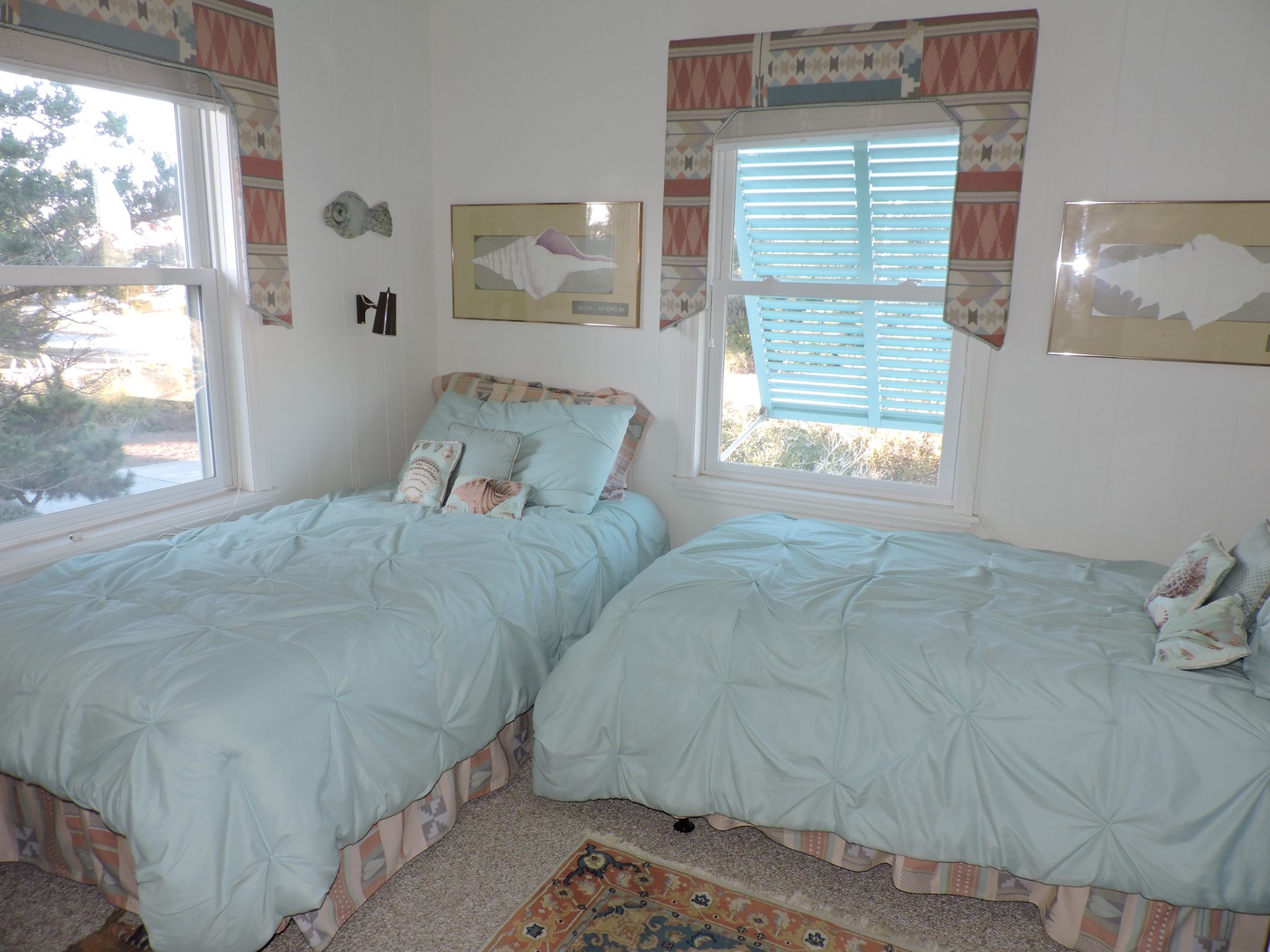 Wake up to soft morning light in your cozy twin bedroom, where plush seafoam bedding and cheerful coastal decor create the perfect restful retreat.