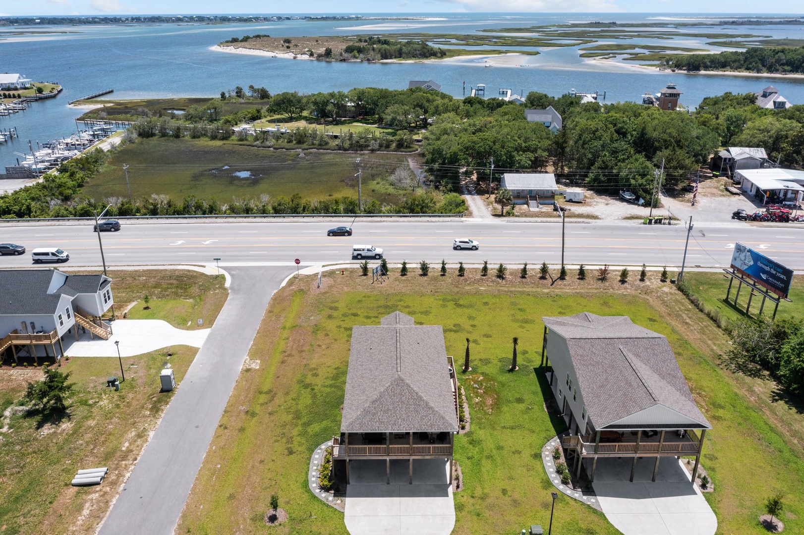 Waterfront properties situated near coastal waters with marina and natural islands in the background.