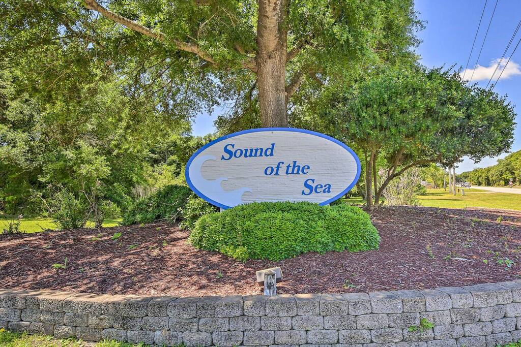 The welcoming entrance sign to Sound of the Sea property, nestled among mature trees and landscaping.