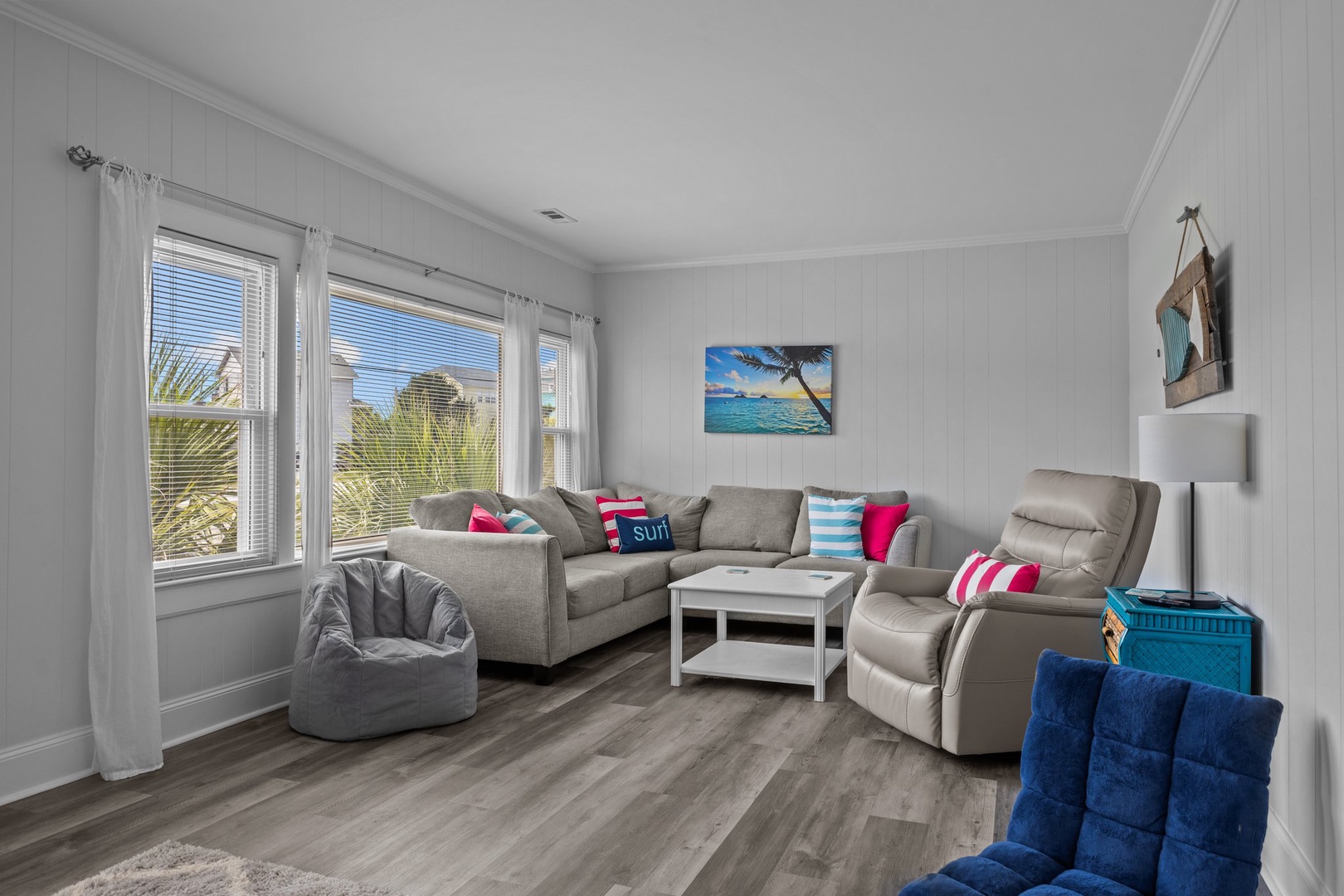 Sink into plush seating and watch the tropical artwork transport you to paradise in this bright, airy living room.