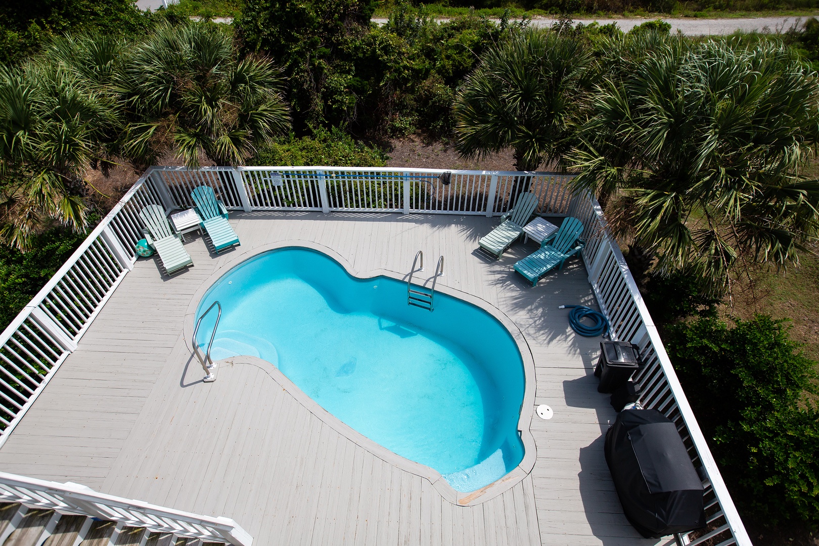 Aerial view of the private pool deck surrounded by tropical landscaping and palm trees.
