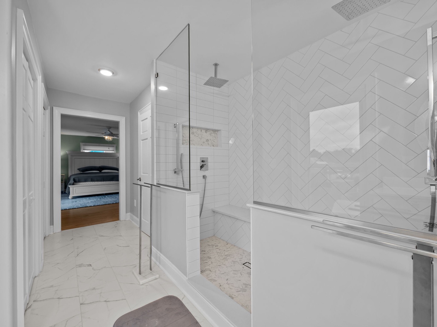 Luxuriate in your spa-like ensuite with rainfall shower, elegant herringbone tile, and marble floors connecting to your bedroom sanctuary.