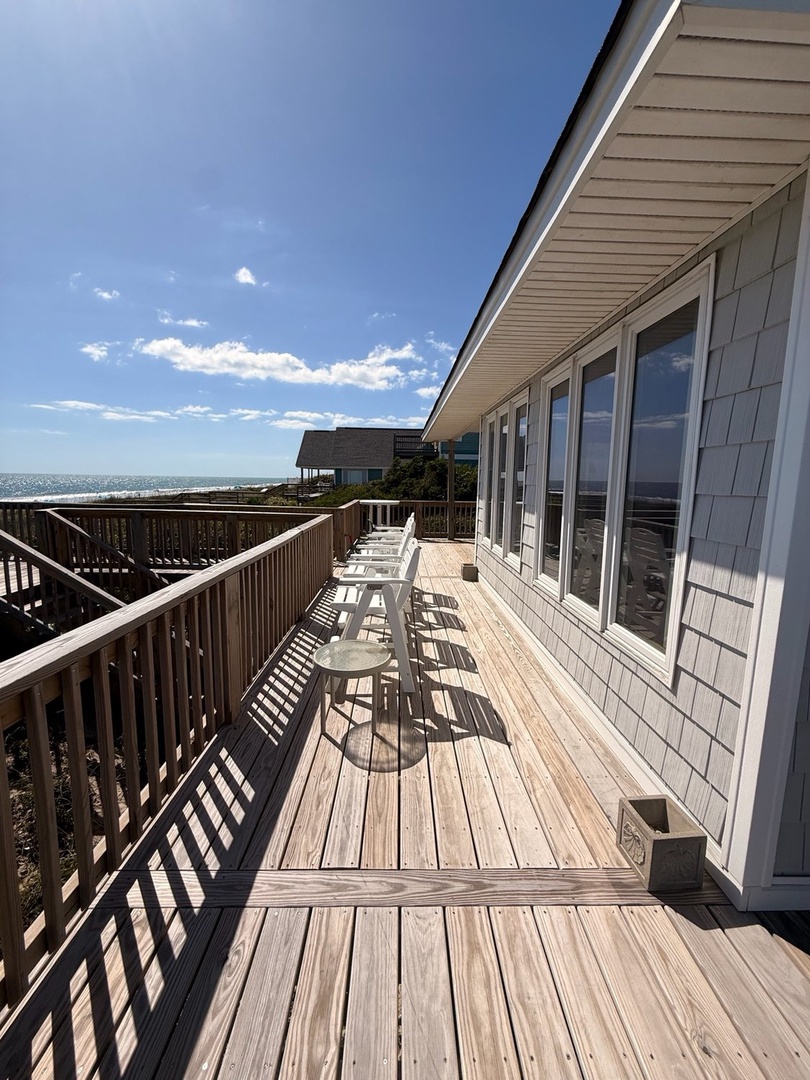 Spacious seaside deck with comfortable seating overlooking a pristine stretch of coastline, perfect for morning coffee or watching the sunset.