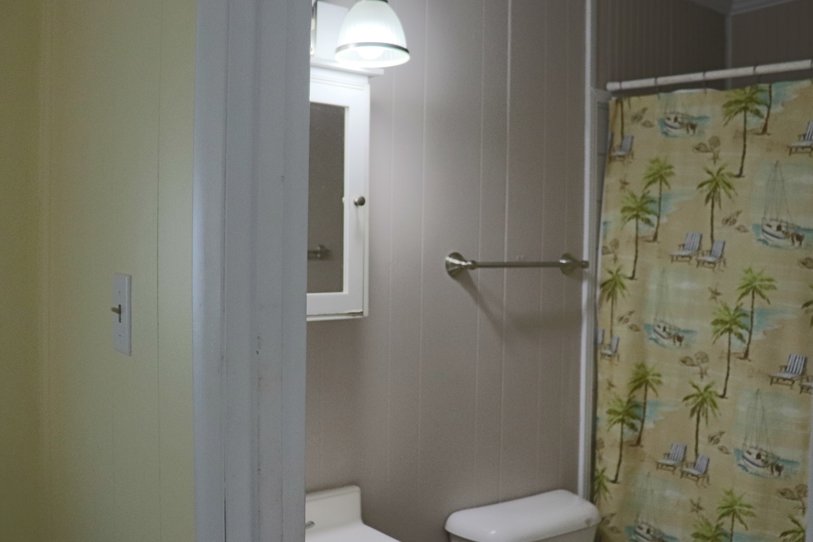 Your private bathroom features a refreshing shower with tropical-themed curtain, perfect for unwinding after your adventures.