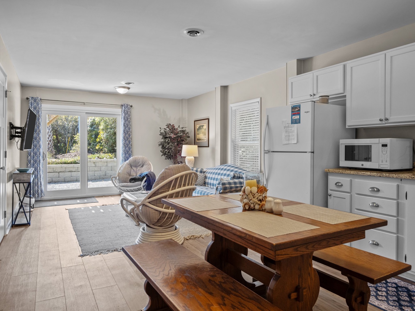 Your bright, open living space seamlessly blends comfort and functionality with a full kitchen, cozy seating, and garden views through sliding doors.