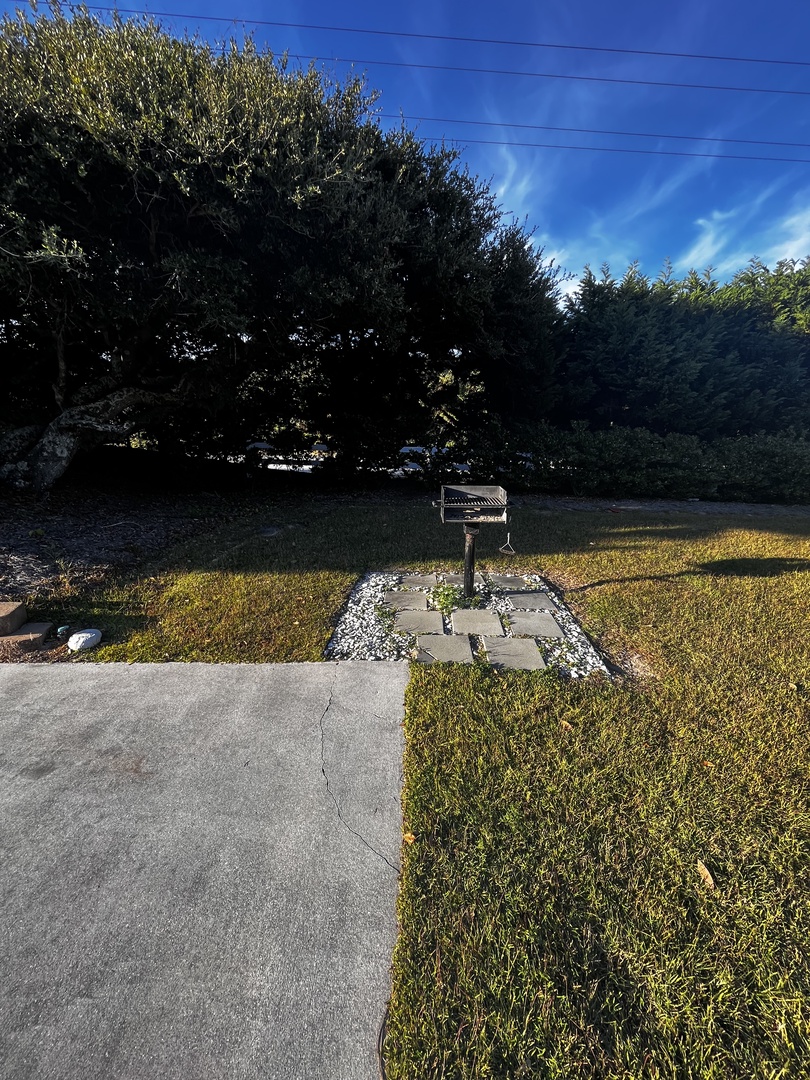 Property entrance with stone pillars and natural landscaping marks your arrival destination.